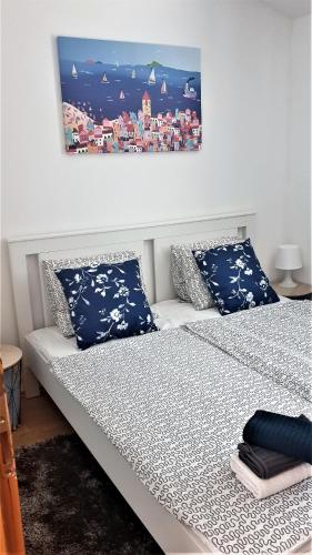 a bedroom with a bed with blue and white pillows at SUMMER NOVALJA Spacious Holiday Home with Private Garden, BBQ & 2 Parking Spaces in Novalja