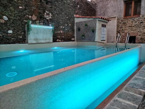 uma piscina com iluminação azul em frente a um edifício em Casa Rural el Rincón de Monfragüe em Malpartida de Plasencia