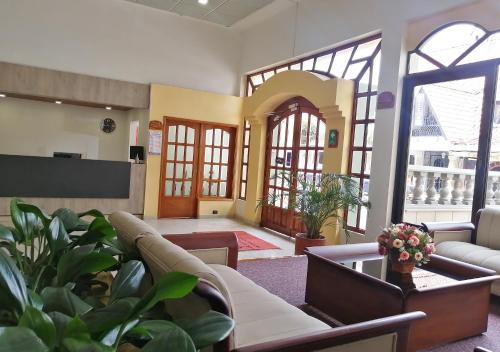 a living room with a couch and some plants at Daza Hotel in Paipa