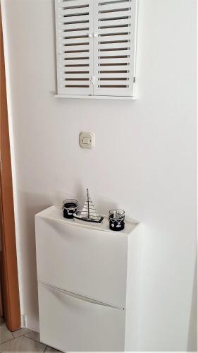 a white refrigerator with two pans on top of it at SUMMER NOVALJA Spacious Holiday Home with Private Garden, BBQ & 2 Parking Spaces in Novalja
