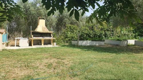 einen Hinterhof mit einem Außengrill im Gras in der Unterkunft Glicine & more Forlì in Forlì