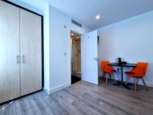 a room with a table and two orange chairs at 146 Studios in London