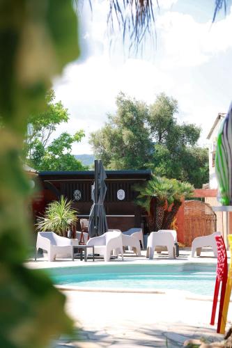 - un groupe de chaises et une piscine dans l'établissement Le Banana's Hotel, à Aléria