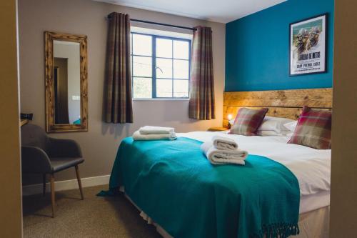 a bedroom with a bed with blue walls and a mirror at Union Road Moto Velo Accommodation in Crediton