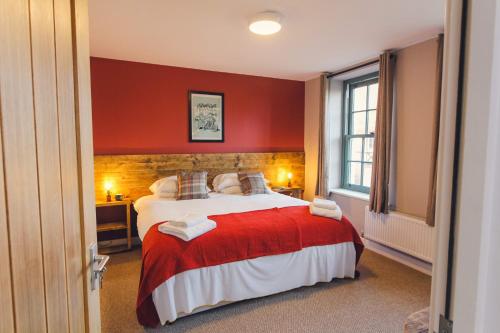 a bedroom with a large bed with a red wall at Union Road Moto Velo Accommodation in Crediton