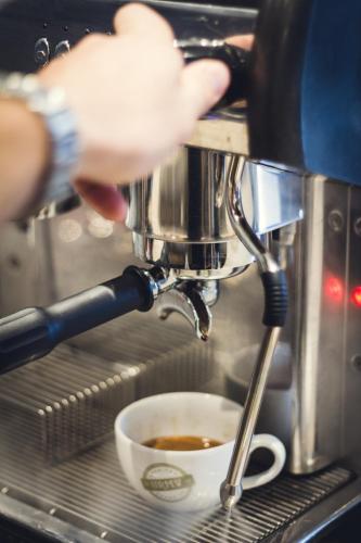 a person is making a cup of coffee at Union Road Moto Velo Accommodation in Crediton