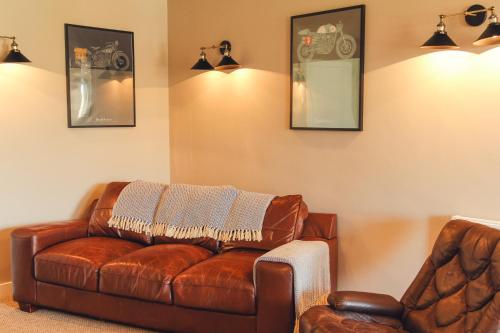 a living room with a leather couch and a chair at Union Road Moto Velo Accommodation in Crediton