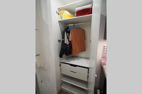 a closet with white shelves and drawers at STUDIO BRICK AND WOOD - HYPERCENTRE - TV - WIFI in Toulouse