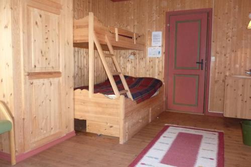 a bedroom with a bunk bed with a red door at Hjartdal Fjellstoge & Storhytte in Hjartdal