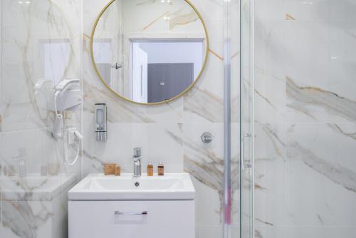 a bathroom with a sink and a mirror at Aquila Hotel in Zator