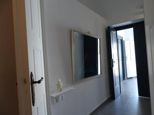 a white room with a mirror and a window at NEOKLASSIKO KOUKOULI in Fira