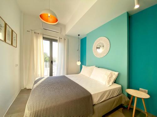 a bedroom with a bed and a blue wall at Marton Perissa in Perissa