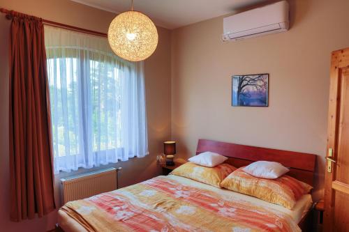 sypialnia z łóżkiem i dużym oknem w obiekcie Apartman Fűzfa w mieście Balatonmáriafürdő