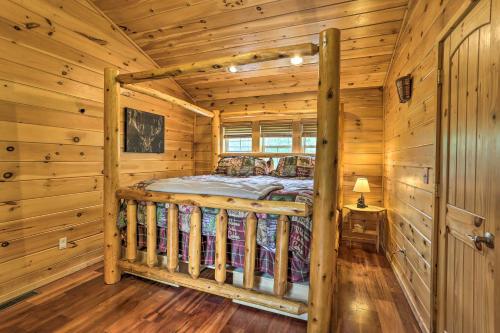 a bedroom with a bed in a log cabin at Porch, Fire Pit and Valley Views Blakely Cabin! in Blakely