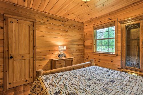 Dormitorio en cabaña de madera con cama y ventana en Charming Blakely Cabin with Porch and Valley Views!, en Blakely