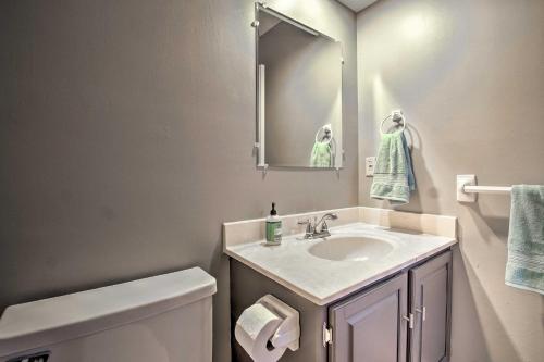 a bathroom with a sink and a toilet and a mirror at Modern Townhome with Fireplace Near Stoll Park in Overland Park