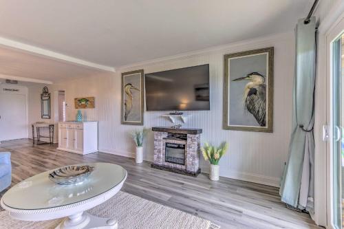 a living room with a fireplace and a tv on the wall at Harbor Island Beach Retreat - Steps to Ocean! in Oceanmarsh Subdivision