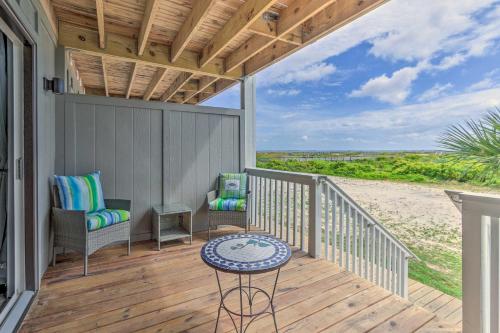 a porch with chairs and a table on a beach at Harbor Island Beach Retreat - Steps to Ocean! in Oceanmarsh Subdivision