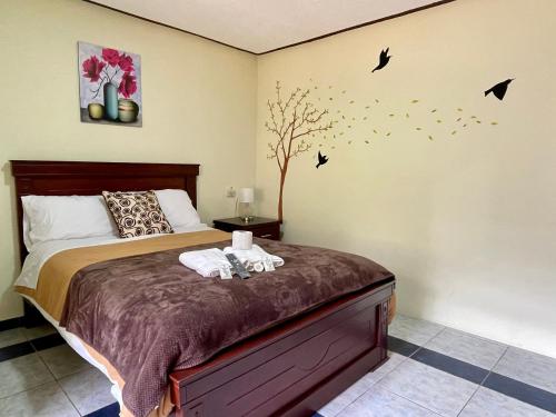 a bedroom with a bed with birds on the wall at Hotel Casa Santa Lucía in Baños