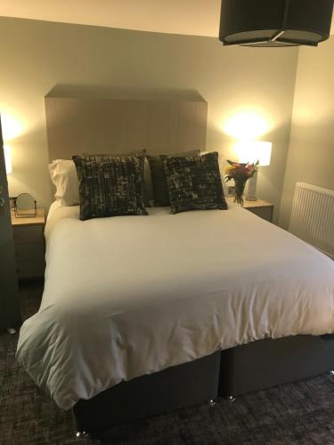 a bedroom with a large white bed with pillows at The Scotts Arms Village Inn in Sicklinghall