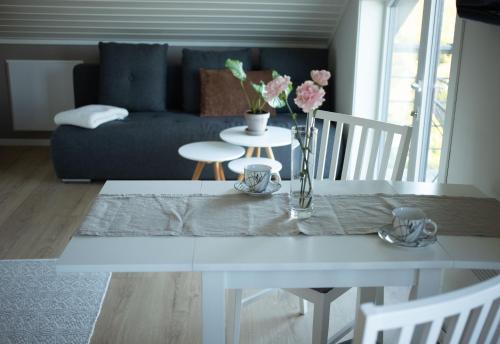 un soggiorno con tavolo bianco e fiori di Kabelvåg Panorama a Kabelvåg