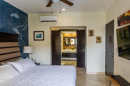 a bedroom with a bed and a bathroom with a sink at Ocean Front El Faro Reef 304 in Playa del Carmen
