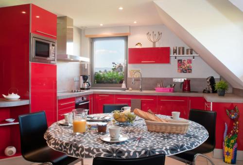 uma cozinha com armários vermelhos e uma mesa com comida em Maison de 2 chambres avec jardin amenage et wifi a Ebersheim em Ebersheim