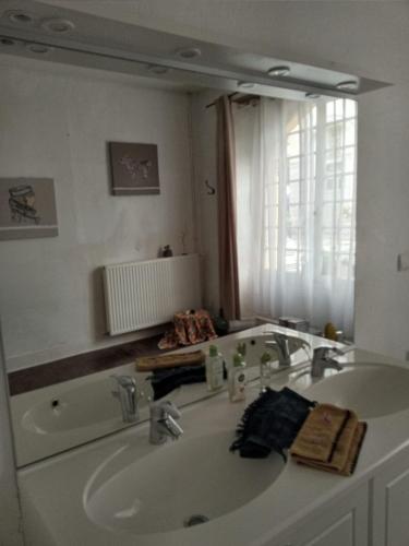 une salle de bain avec un lavabo et un grand miroir dans l'établissement Villa Imaginaire, à Maubourguet