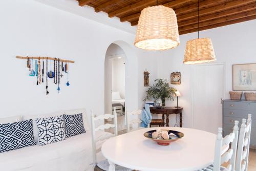 a white dining room with a white table and chairs at Charming House Platy Gialos in Platis Yialos Mykonos