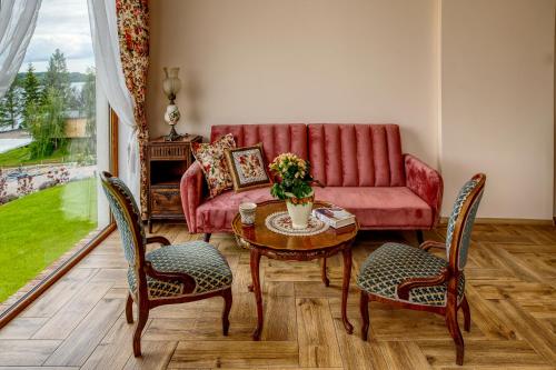 a living room with a couch and a table and chairs at Czapla Stare Sady in Mikołajki