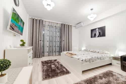 a white bedroom with a bed and a couch at URBAN LUXURY in Constanţa