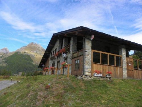 a house on top of a hill with a mountain at Hotel Les Granges in La Thuile