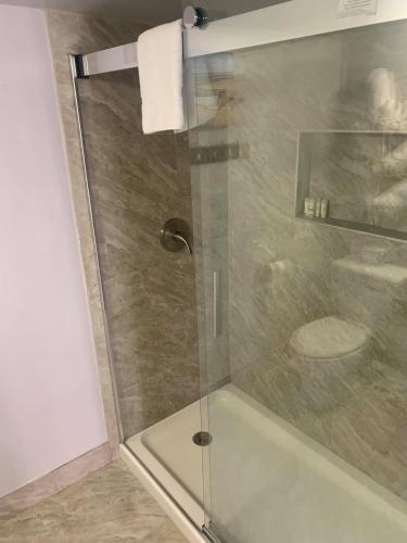 a shower with a glass door in a bathroom at Ocean Manor 1100 Inn in Ocean City