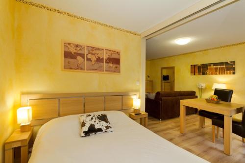イゾラ 2000にあるRésidence mmv Les terrasses d'Isolaのベッドルーム1室(ベッド1台、デスク、ソファ付)