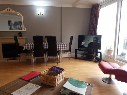 a living room with a table and a tv at The Old Shipyard in West Bay