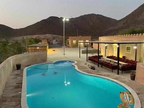 a large blue swimming pool in front of a building at Alshahad farmhouse in Fujairah