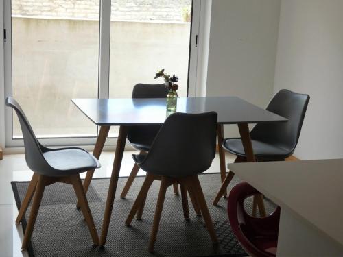 a table with four chairs and a bottle on it at Villa Barrinha in Praia de Mira