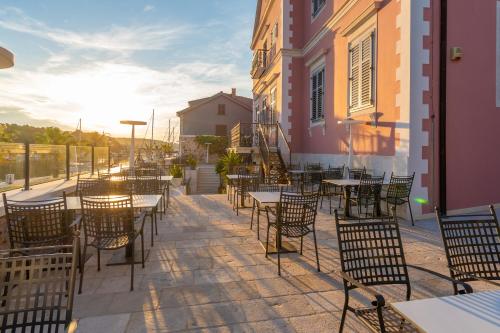 a patio area with tables and chairs and umbrellas at B&B Heritage Villa Apolon in Stari Grad