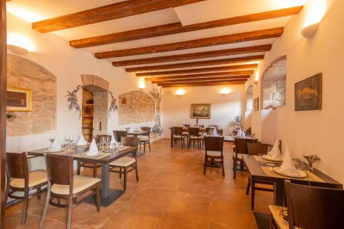 un restaurant avec des plafonds en bois, des tables et des chaises dans l'établissement B&B Heritage Villa Apolon, à Stari Grad