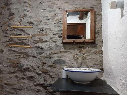 a stone bathroom with a sink and a window at La Abuela Mercedes en Trevélez in Trevélez