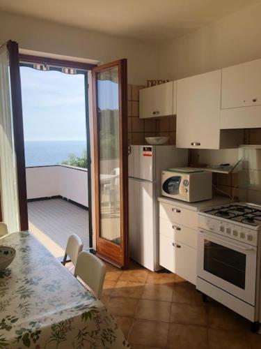 a kitchen with a table and a stove top oven at Casa Orchidea - Vista Mare meravigliosa in Bonassola