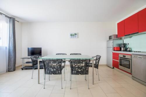 une cuisine avec des armoires rouges et une table et des chaises dans l'établissement Bright Apartment In The Heart Of Cannes, à Cannes
