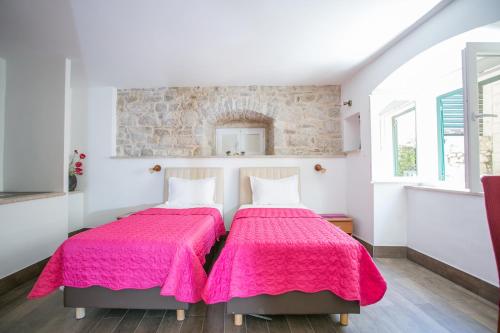 - 2 lits dans une chambre avec des couvertures roses dans l'établissement Garden Apartment Hotel, à Split