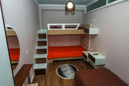 a small room with a bunk bed with a red mattress at Edea's Apartment in Korçë
