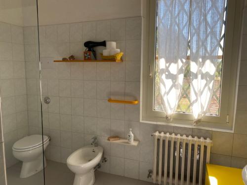 a bathroom with a toilet and a sink and a window at Adamasseria in Collecorvino