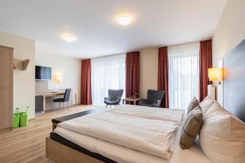 a hotel room with a bed and a desk at Hotel Dirsch Wellness & Spa Resort in Emsing