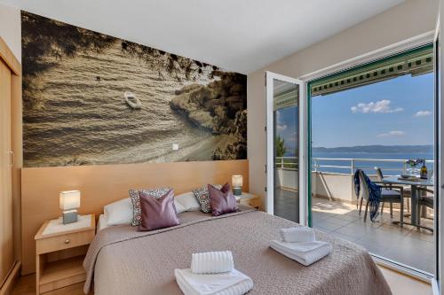 - une chambre avec un lit et une vue sur l'océan dans l'établissement Apartments Vranjes, à Brela