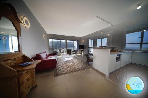 un salon avec un canapé rouge et une cuisine dans l'établissement UNE TERRASSE SUR LA MER 3 pers 2 chambres VUE MER, à Cassis