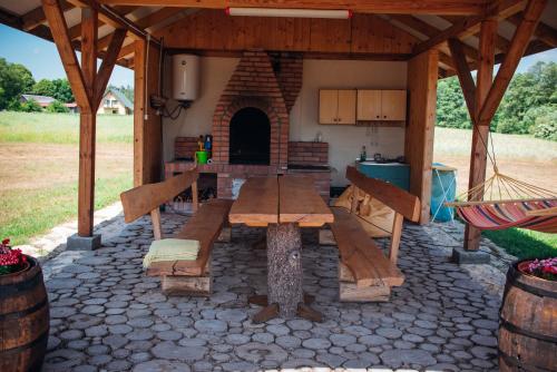 a patio with a wooden table and a kitchen at Na Piaskach Domek na Roztoczu in Narol