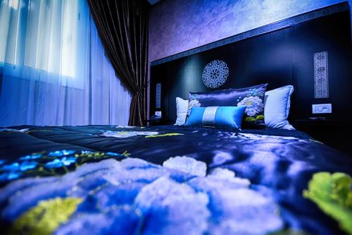 a bedroom with a large bed with blue and white pillows at Hotel Vents Des Iles in Essaouira